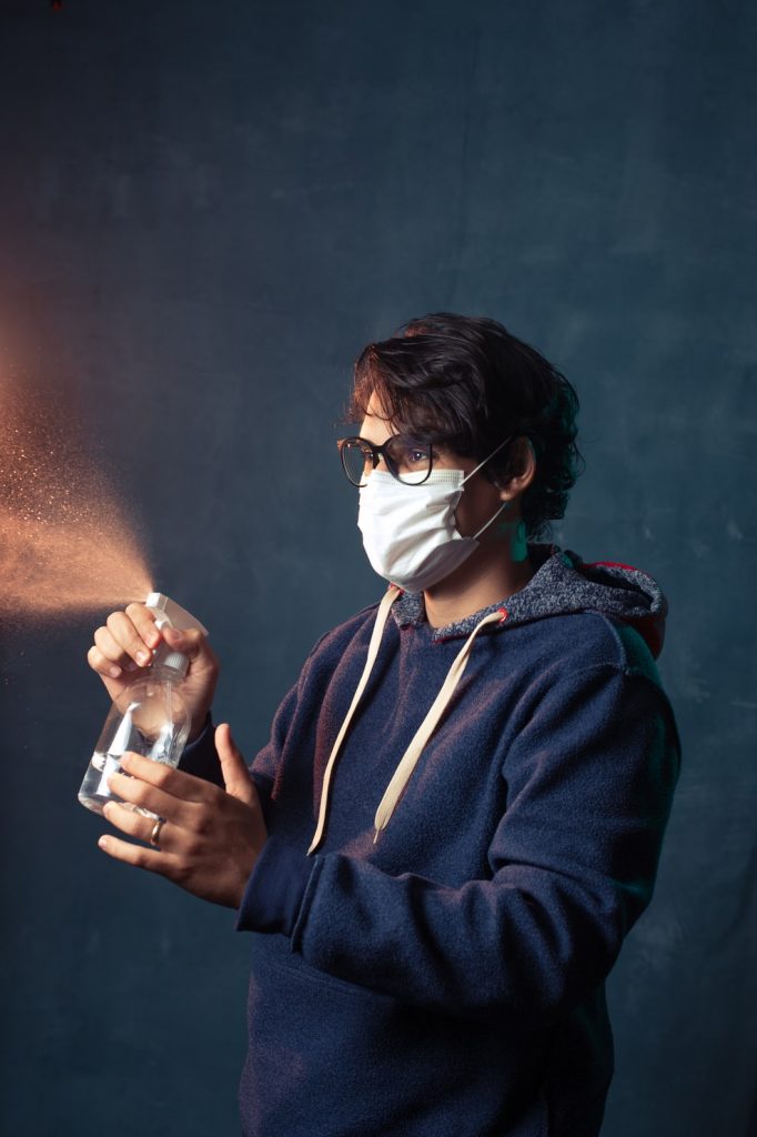 3 a person spraying a bottle with a mask on